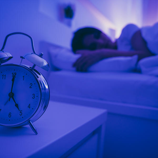 Header image for blog post, titled, "3 Tips to Cope with Daylight Saving Time, by Sarah Moe, Sleep Expert and AMEC Member"Picture of woman sleeping in bed next to alarm clock on the nightstand.